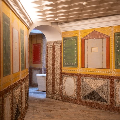 Historic Juderia: Sevilla spa with Roman-inspired decor, mosaic walls, and a standalone tub.