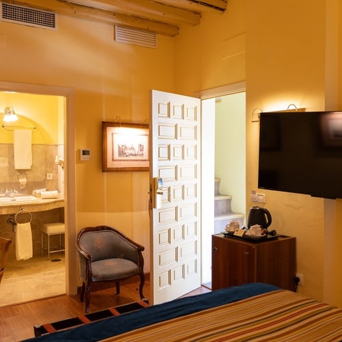 Cozy hotel room with bathroom, TV, and seating, located in Juderia: Sevilla.