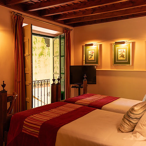 Chambre double avec lits jumeaux, balcon, tableaux et décor classique. Idéal pour un séjour à Juderia: Sevilla.