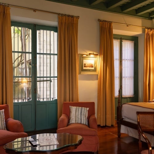 Classic room with dual beds in Juderia: Sevilla, featuring ornate woodwork and traditional decor.