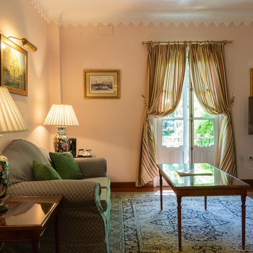Elegant living room with ornate rug and window views, perfect for your Juderia: Sevilla stay.