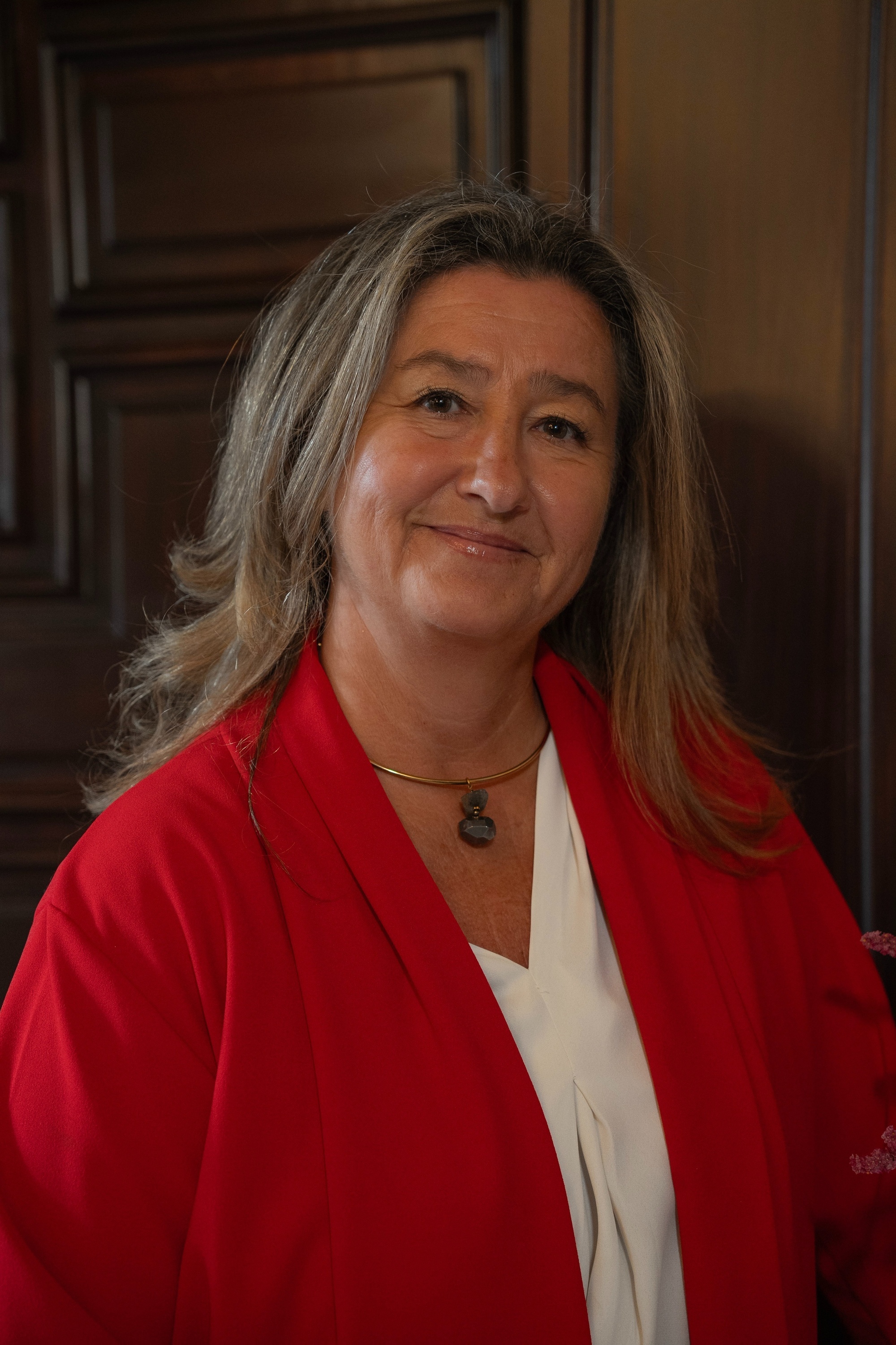  a woman wearing a red jacket and a necklace with the number 8 on it 