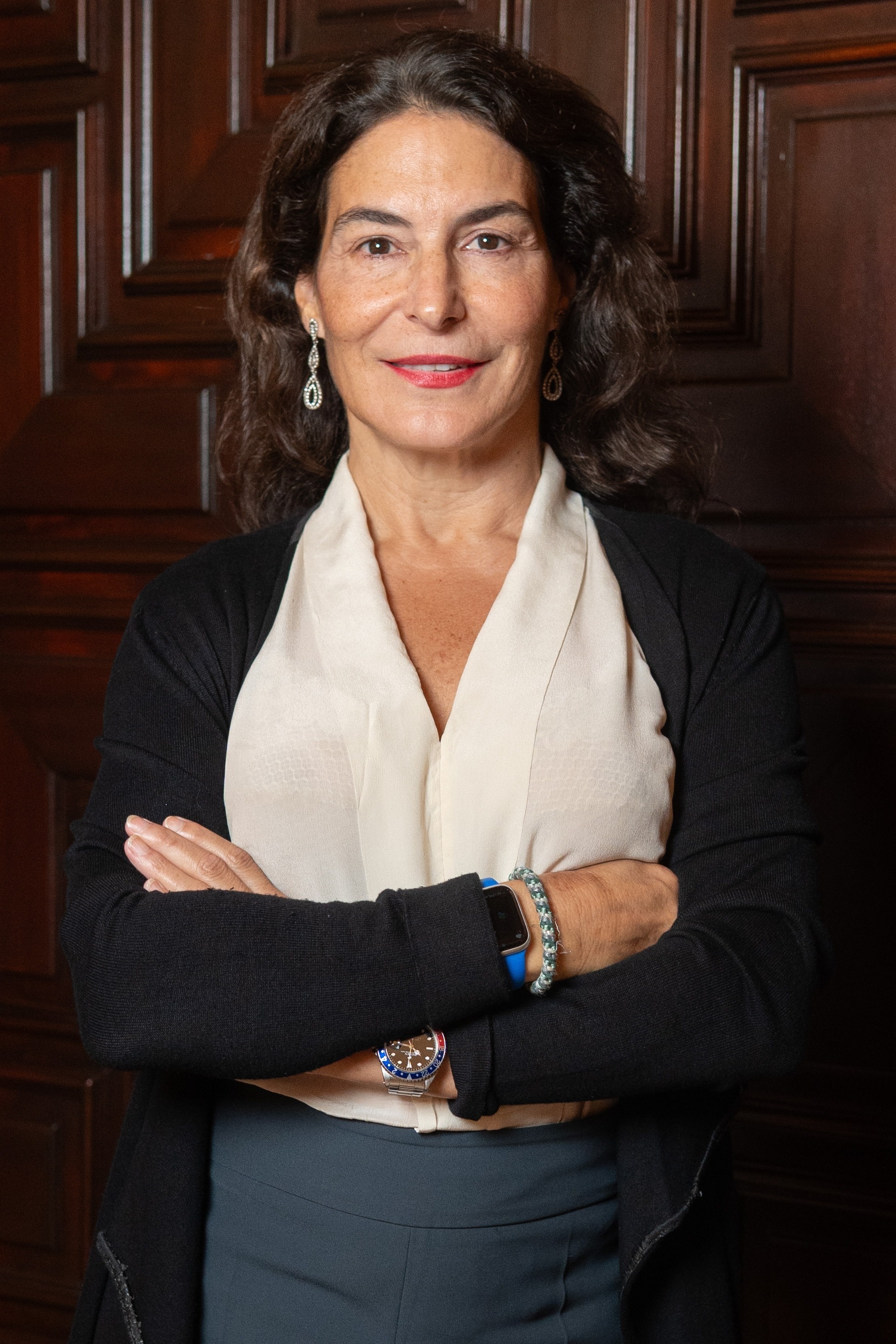  a man in a suit and tie stands with his arms crossed 