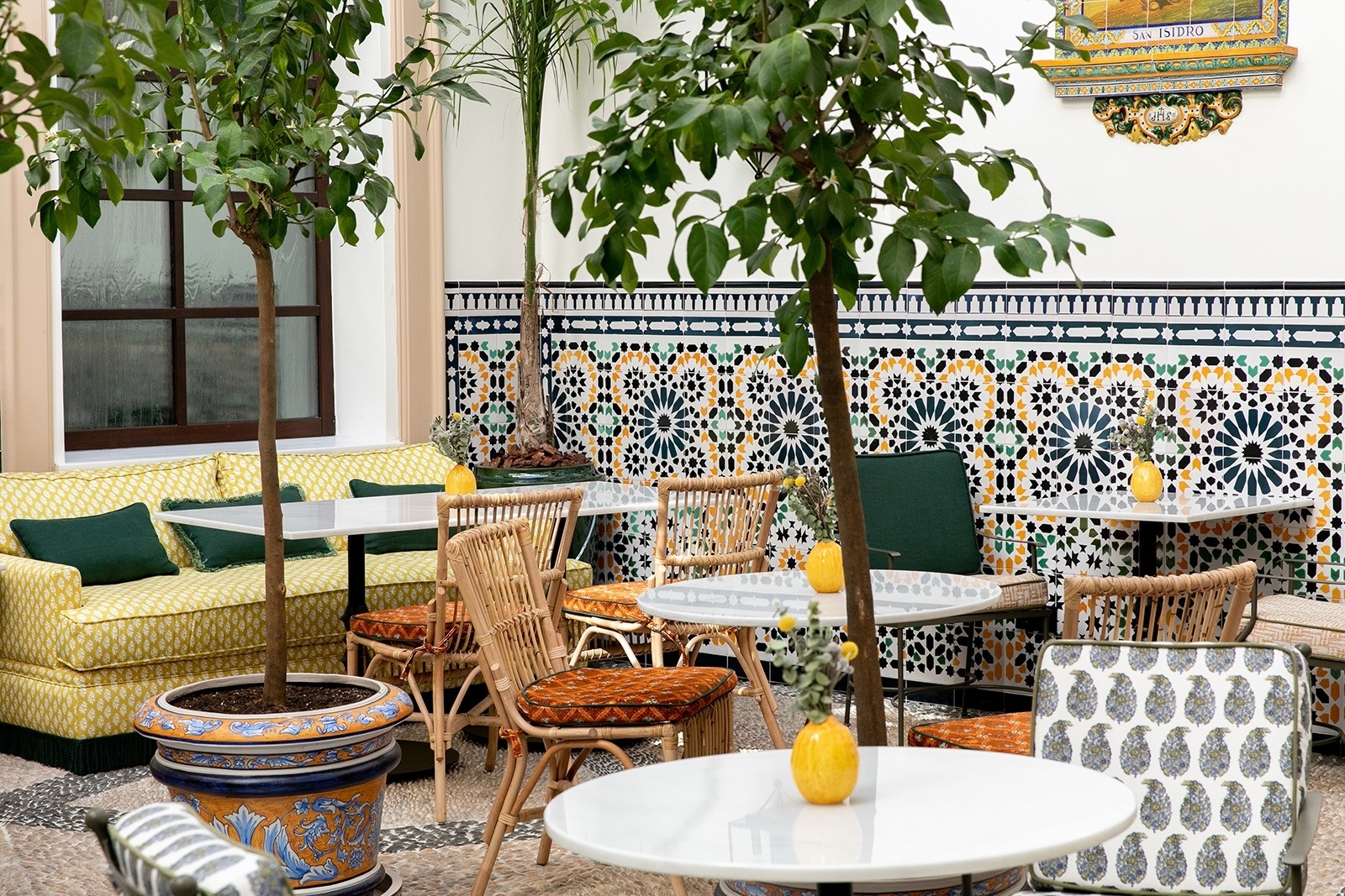 un patio con mesas y sillas y un sofá amarillo