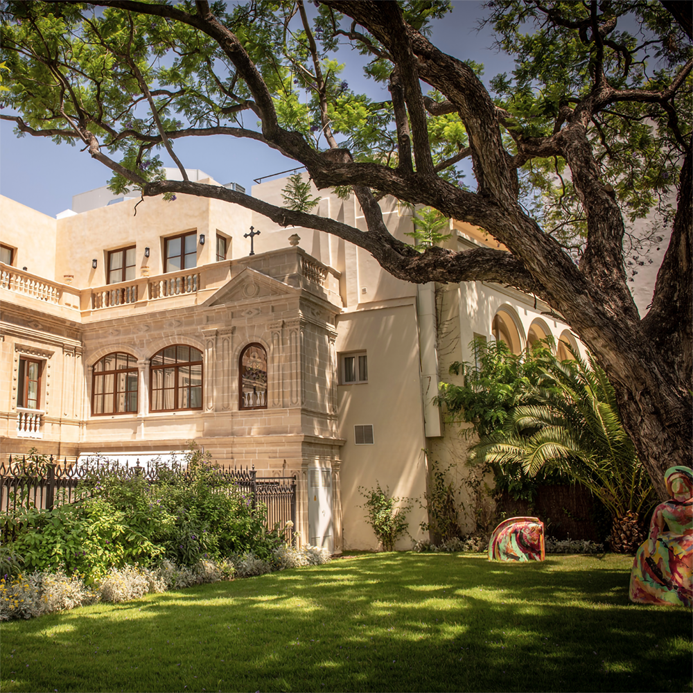 un edificio antiguo con un gran árbol al frente
