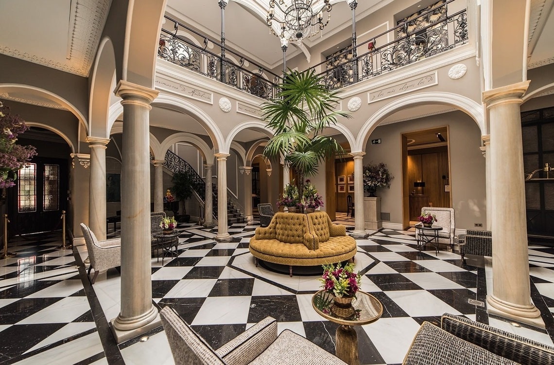 una sala de estar con un sofá amarillo y un suelo a cuadros