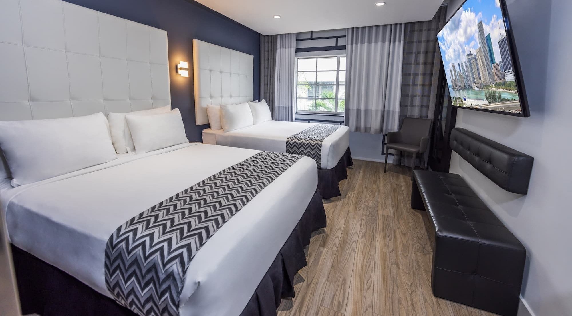 a hotel room with a large flat screen tv above the bed