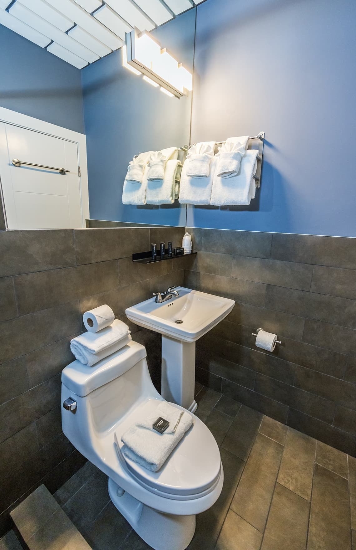 un baño con un inodoro y un lavabo con toallas encima