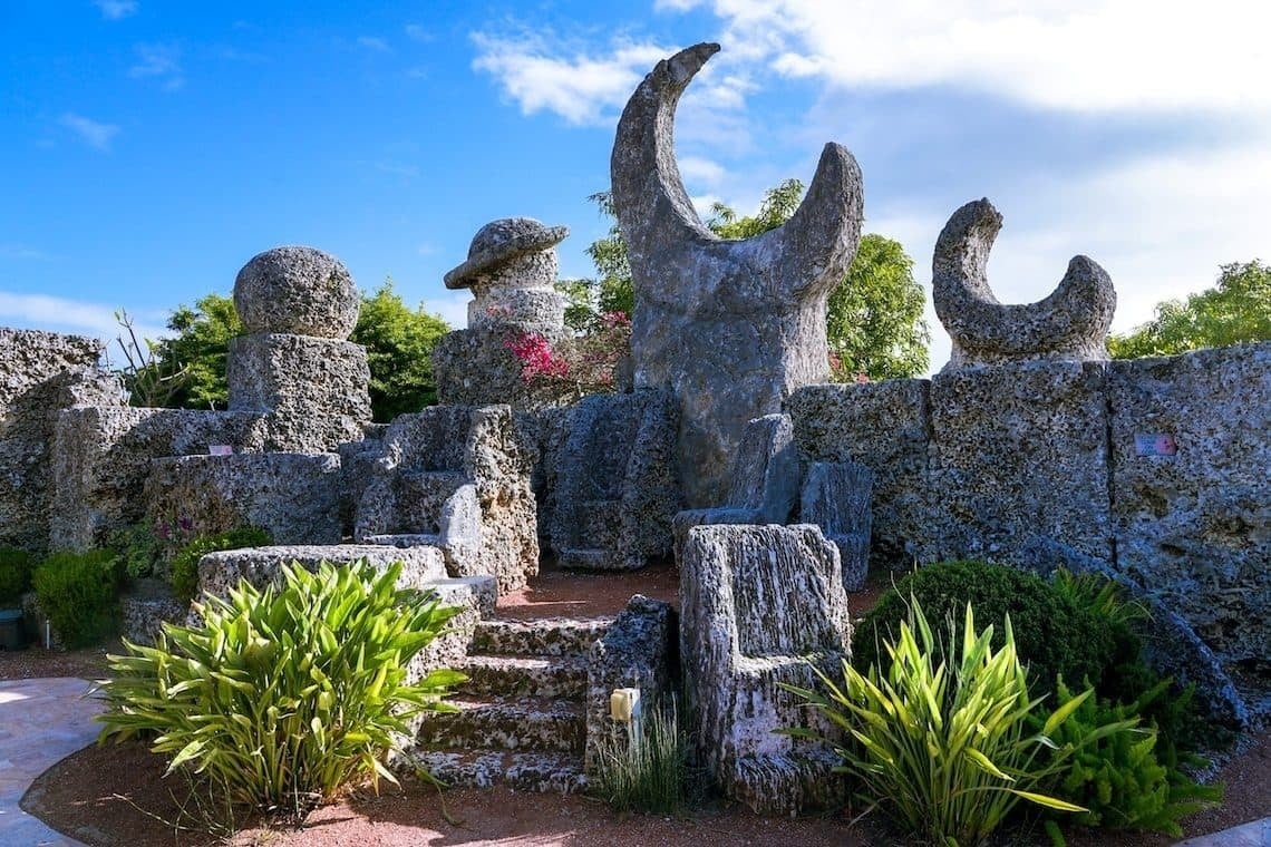 una gran estatua de coral en un jardín rodeado de plantas