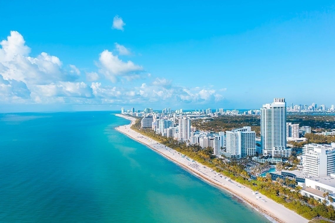 an aerial view of a beach with a city in the background