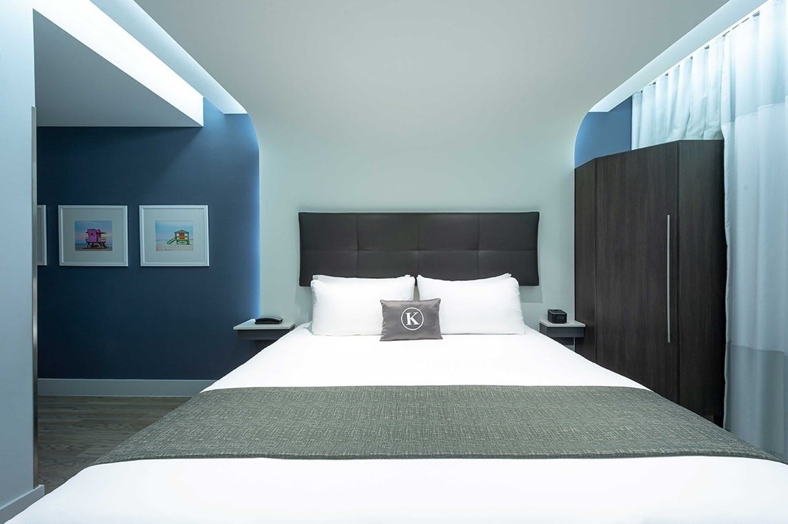 una cama con una almohada con la letra k en ella