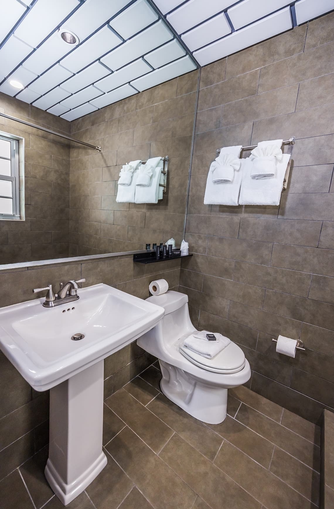 un baño con inodoro , lavabo y espejo