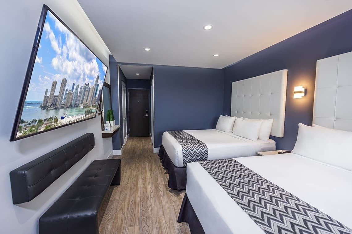 una habitación de hotel con dos camas y una televisión en la pared