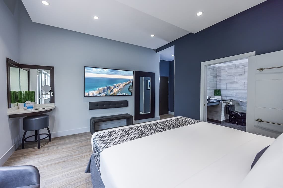 una habitación de hotel con una cama y una televisión en la pared