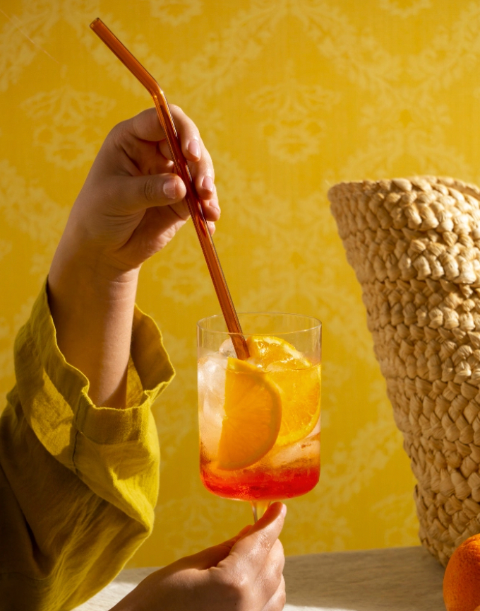 a woman is dipping a piece of oysters into a cocktail .
