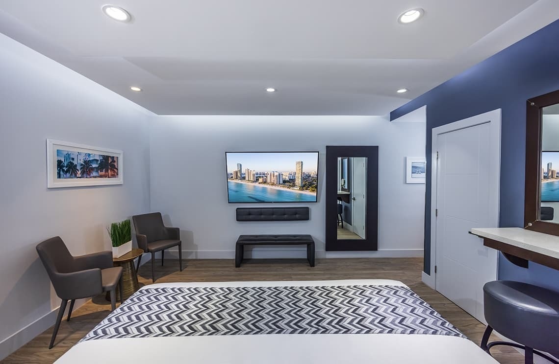 una habitación con una cama y una televisión en la pared