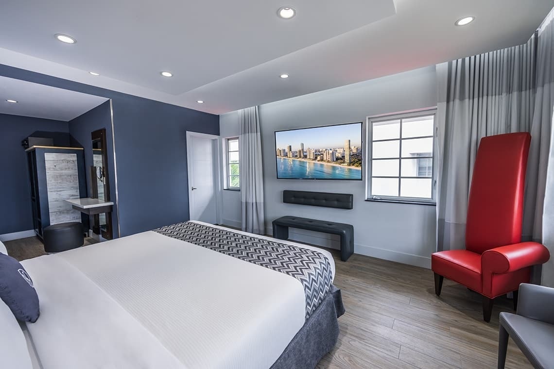 una habitación de hotel con una cama y una televisión en la pared