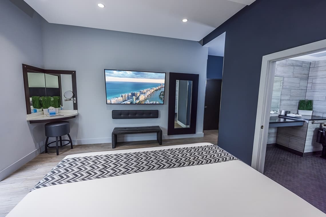 un dormitorio con una cama y una televisión en la pared