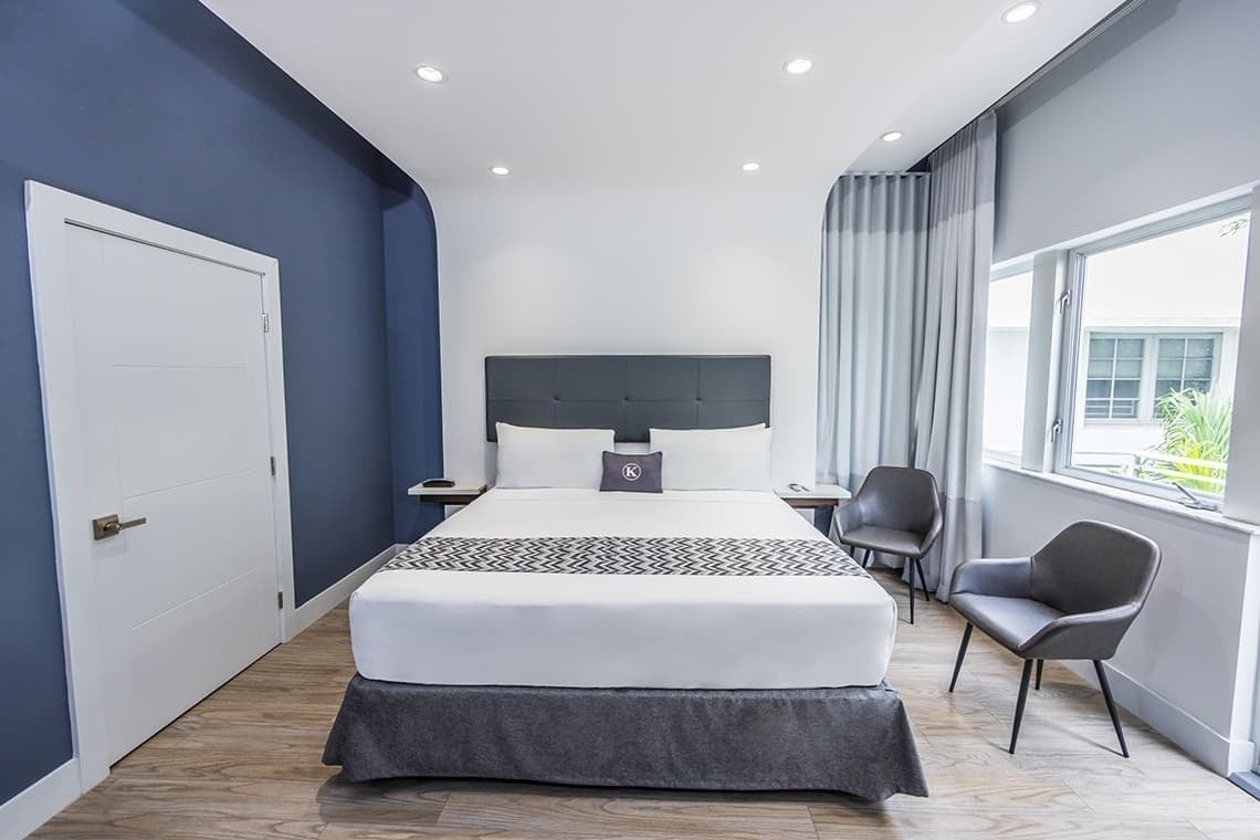 una habitación de hotel con una cama y dos sillas