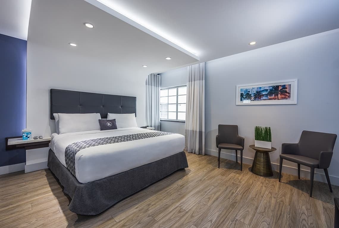 una habitación de hotel con una cama y dos sillas