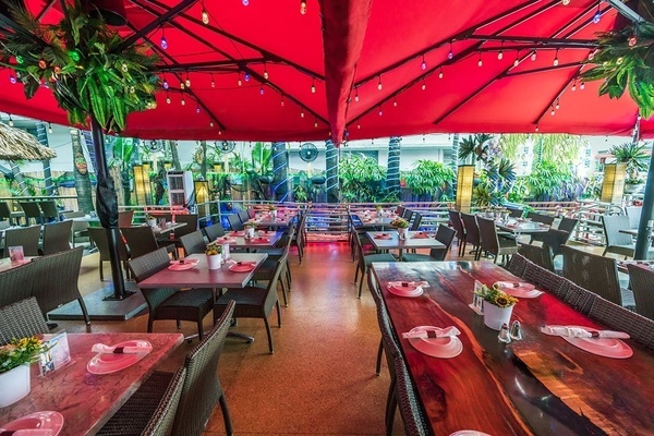 a restaurant with tables and chairs under red umbrellas