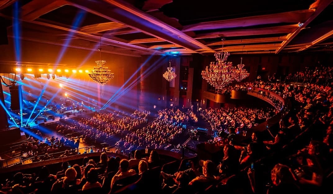 un gran auditorio lleno de gente viendo un concierto