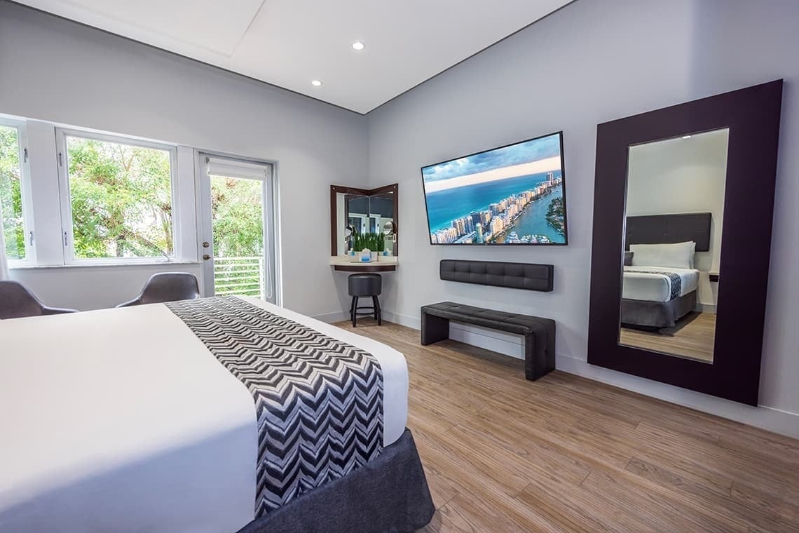 una habitación con una cama y un televisor en la pared