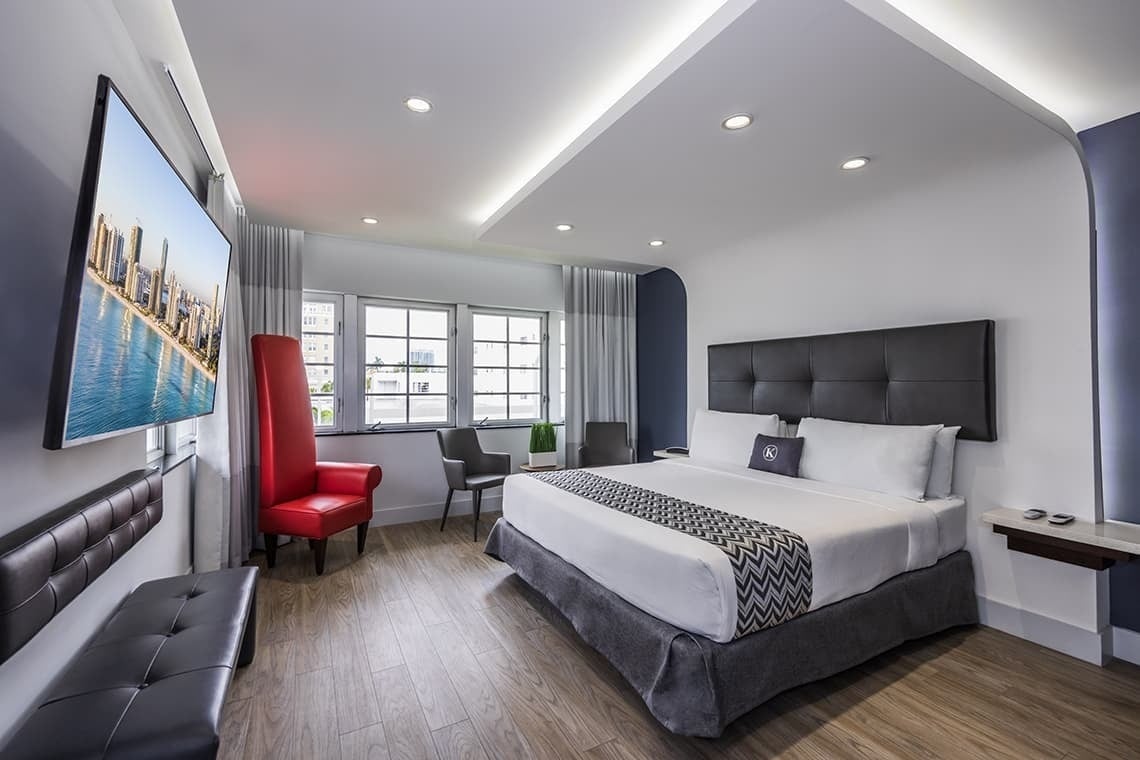 una habitación de hotel con una cama king size y una silla roja