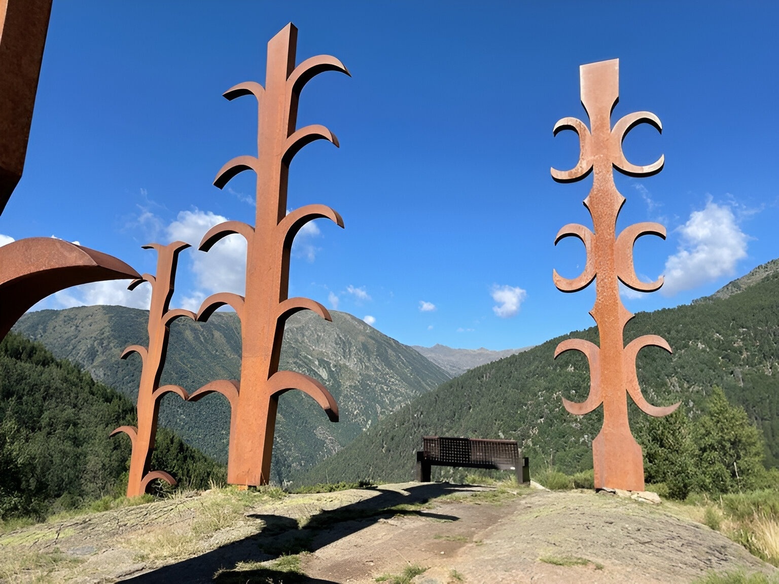 un home i una anciana amb mochilas caminant a través d' un bosquet