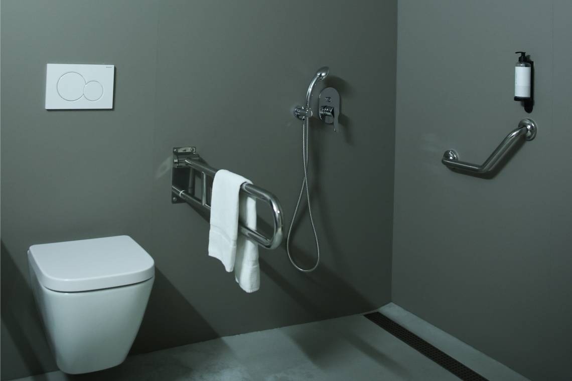 un baño con un inodoro y un dispensador de jabón