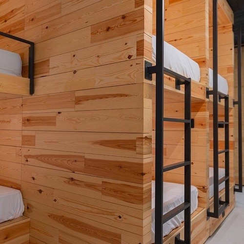 una fila de llits apilables de fusta amb escales