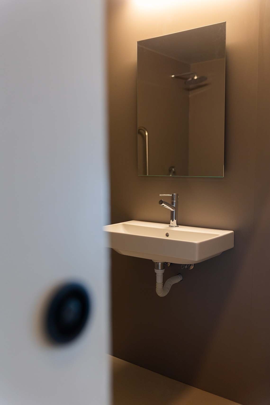 una cama con sábanas blancas y almohadas en una habitación de hotel