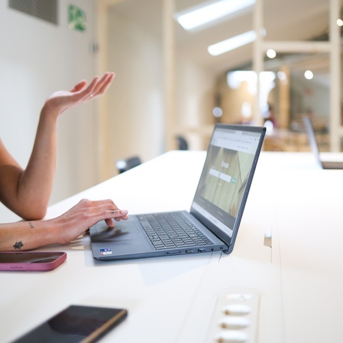 una persona està usant un lap top a una mesa blanca