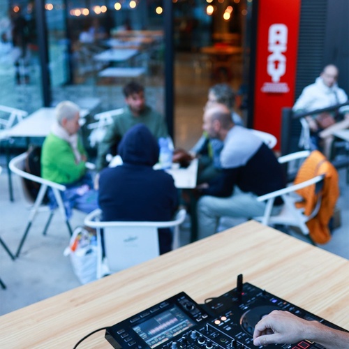 un dj toca la música en una mesa de madera a l' aire lliure