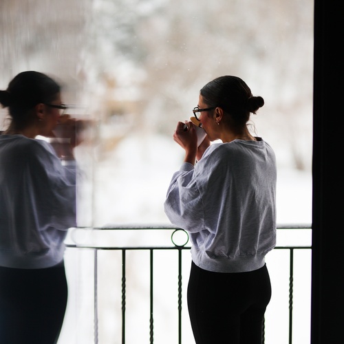 Chica tomando una bebida caliente en el Hostel