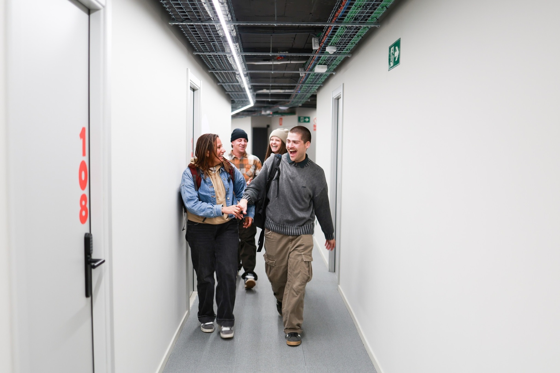 Young people laughing in the hallway of KY Hostel – Accommodation in Arinsal.