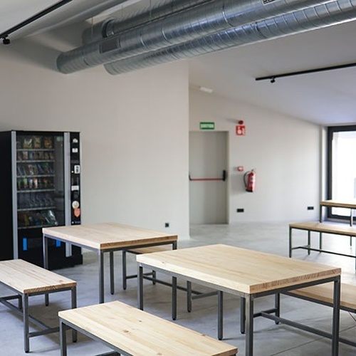 una sala de menjar amb taules de fusta i bancs