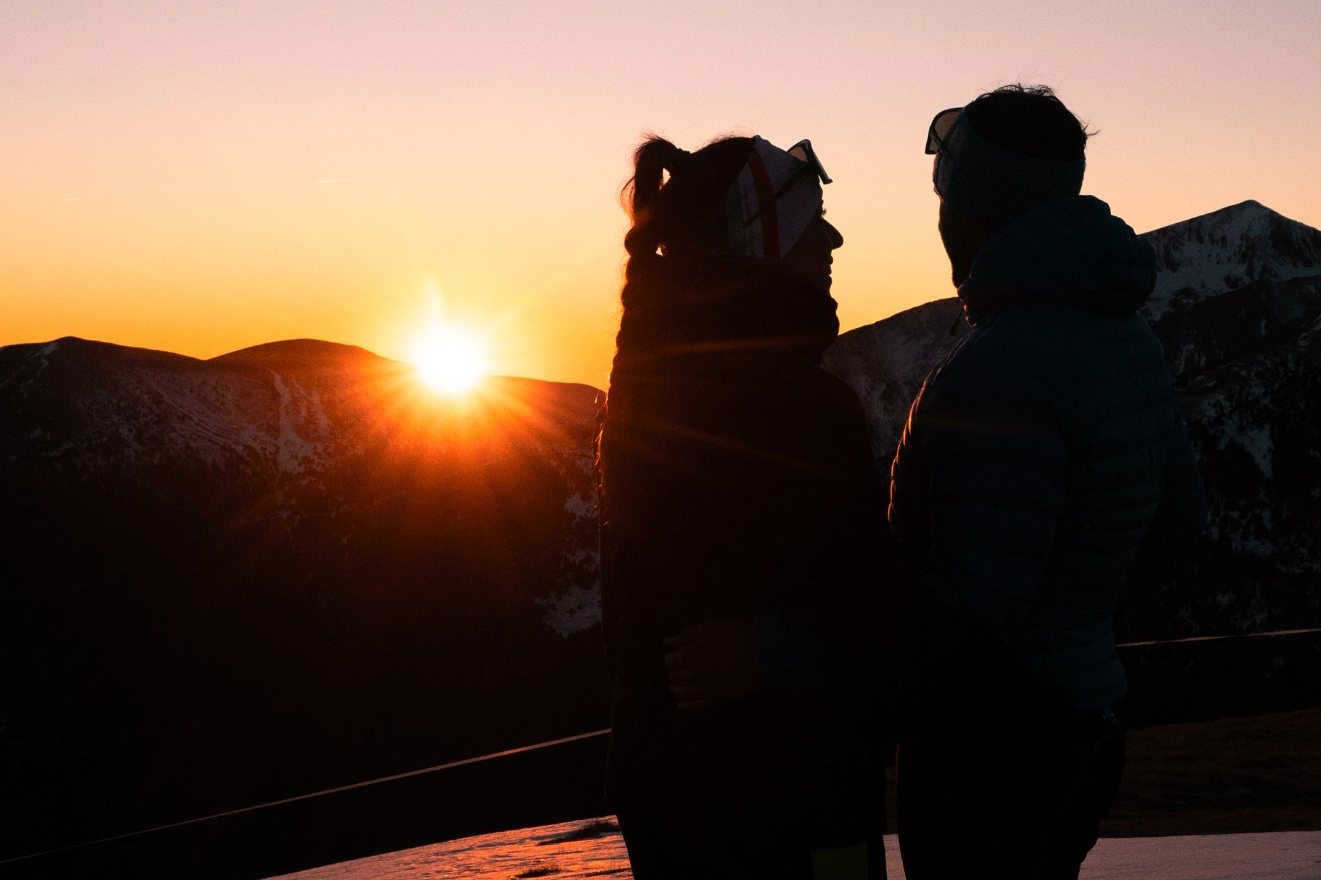 Pareja de esquiadores en una puesta de sol en Pal Arinsal