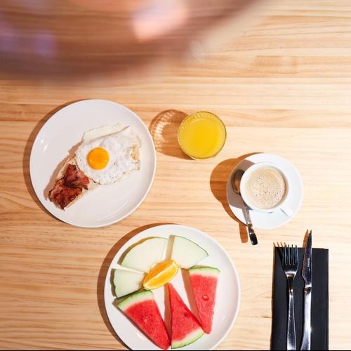 una mesa de madera con platos de comida y un vaso de zumo de naranja