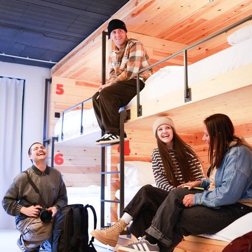 Grupo de amigos converssando en una habitación con lliteras