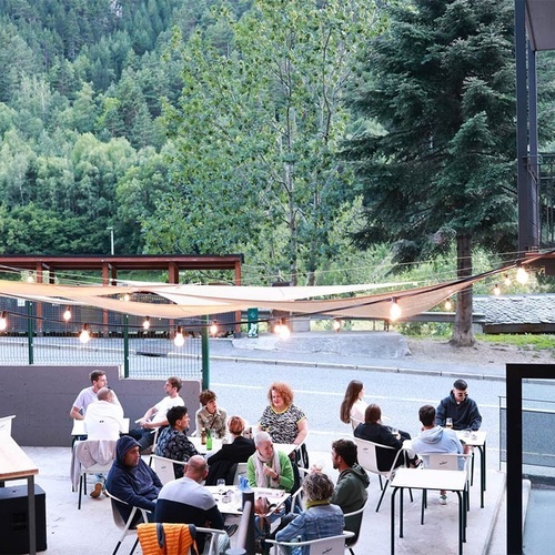 un grup de persones sent-se a l' aire lliure en una terrassa