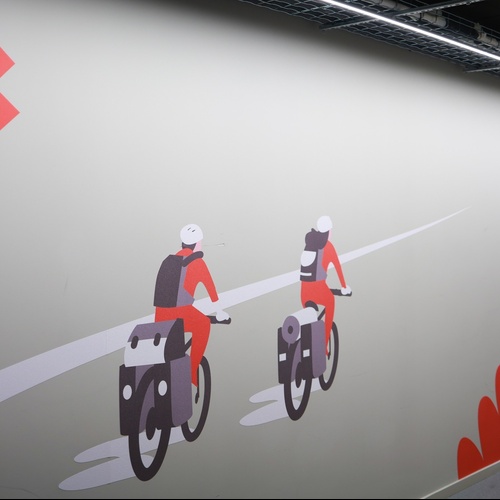 dues persones en bicicleta a l' esquerra i a la dreta d' un corredor