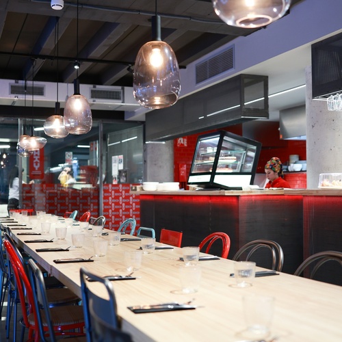 una sala de menjar amb unes taules i cadires vermelles