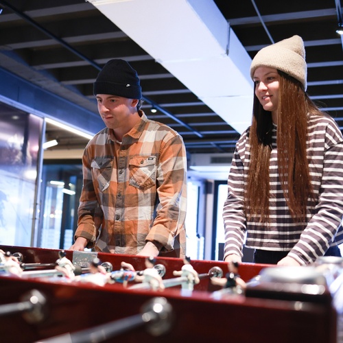 Dos jóvenes jugando al futbolín en KY Hostel