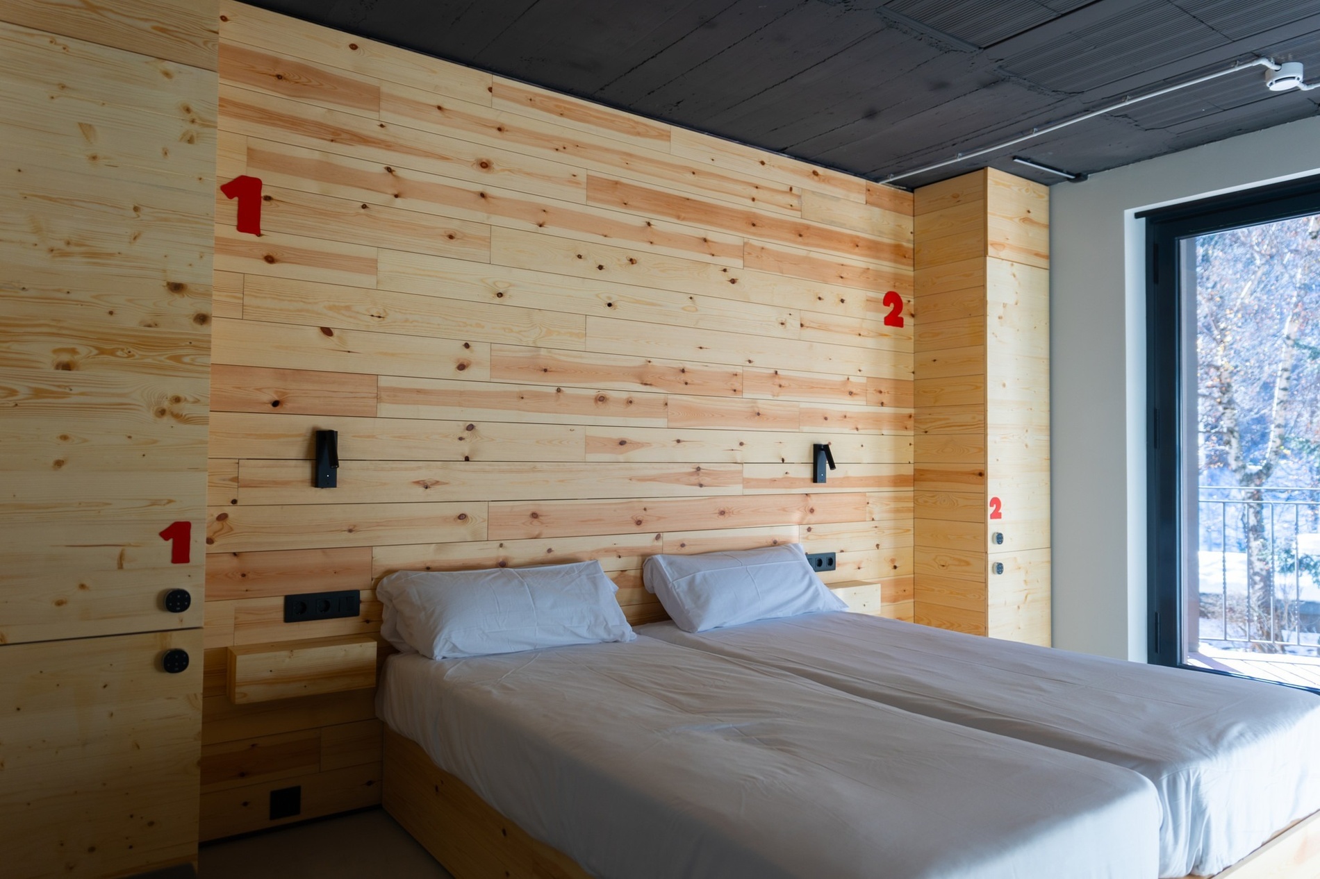 una habitación con una cama y una pared de madera con los números 1 y 2