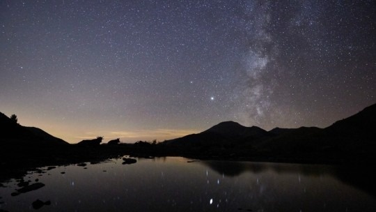 Noche estrellada sobre lago y montañas, ideal para una estancia en Daguisa: KY Hostel.