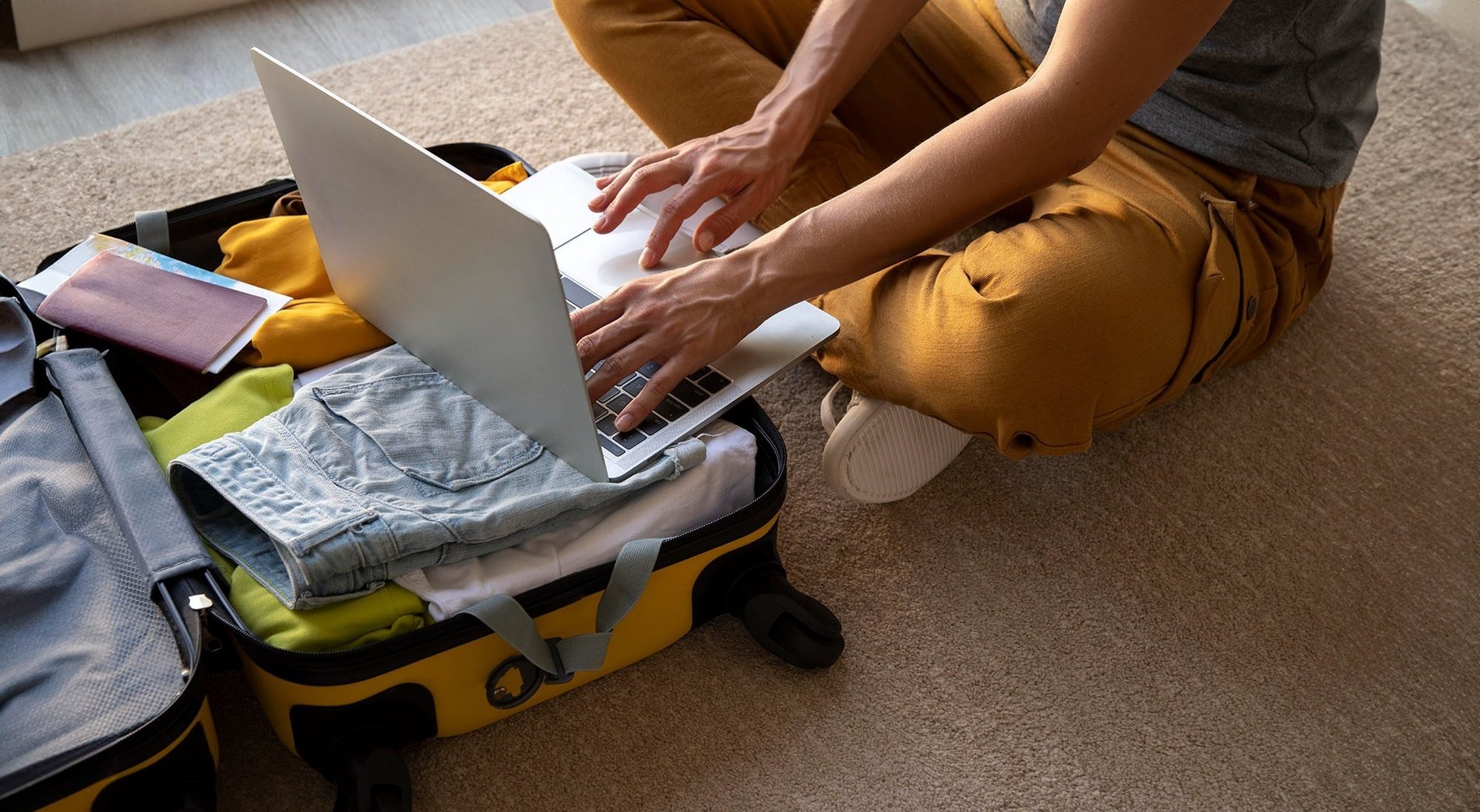 una persona está sentada en el suelo usando una computadora portátil