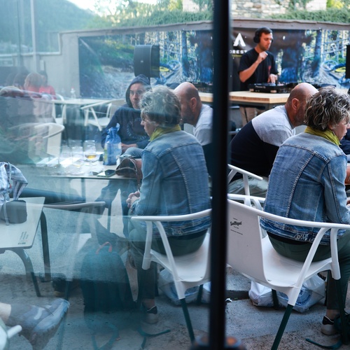 un grup de persones sent-se a l' aire lliure en un restaurant
