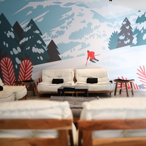 una sala de estar amb sofàs i una imatge d' un esquiador