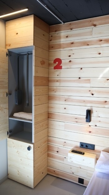 Habitación moderna de hostel con pared y armario de madera, ideal para Hostel + Forfait Bike Park Andorra | Pal Arinsal 2026.